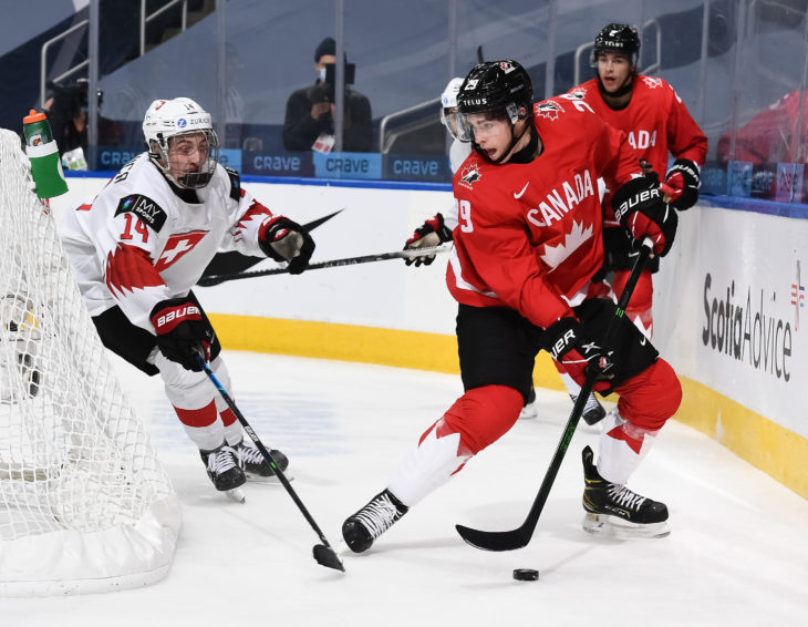EDMONTON, AB CANADA - DECEMBER 29: Canada's Jack Quinn #29 plays the puck while Switzerland's Lorenzo Canonica #14 defends during preliminary round action at the 2021 IIHF World Junior Championship at Rogers Place on December 29, 2020 in Edmonton, AB Canada. (Photo by Andrea Cardin/HHOF-IIHF Images)